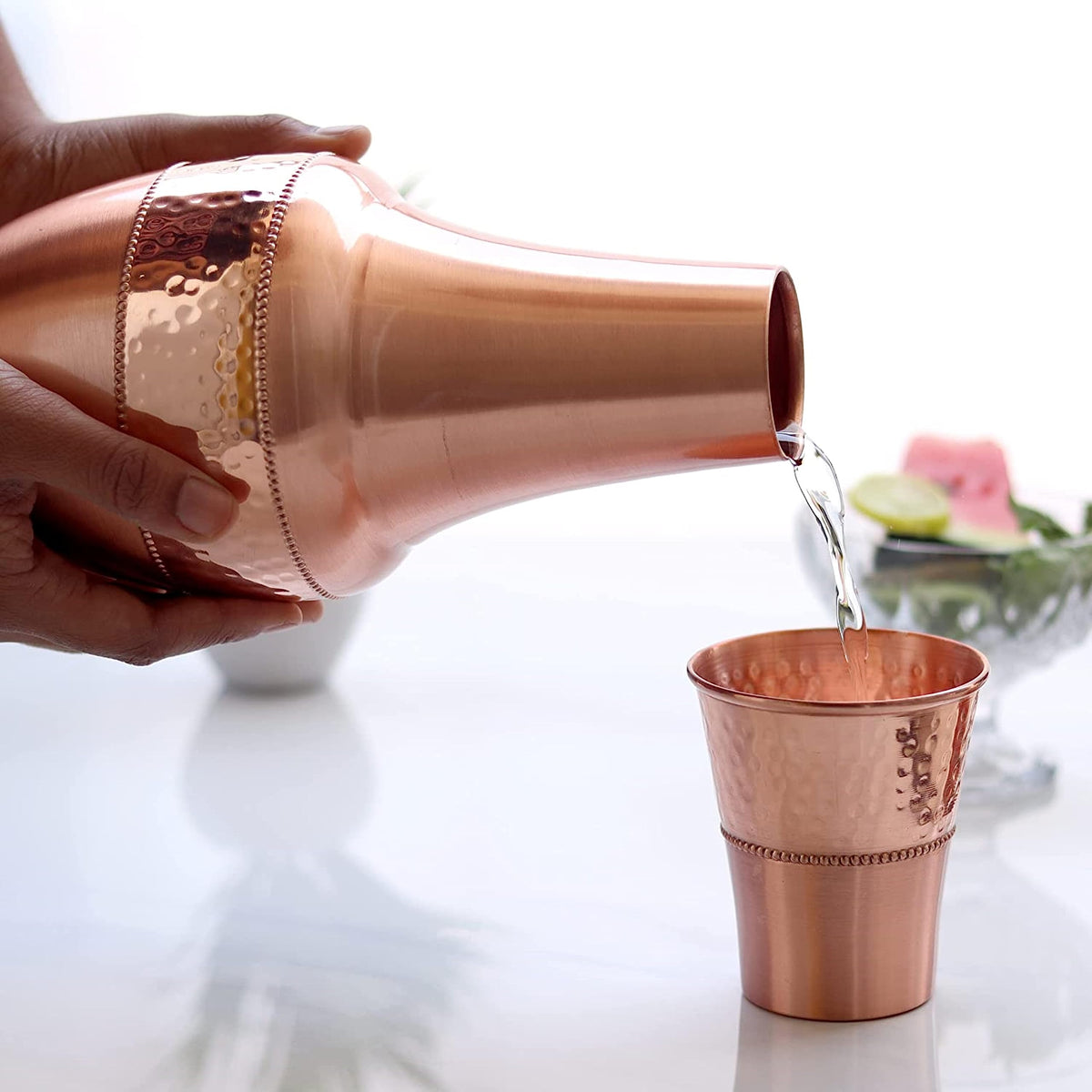 2activelife handcrafted copper carafe and tumbler pair on a shelf.
