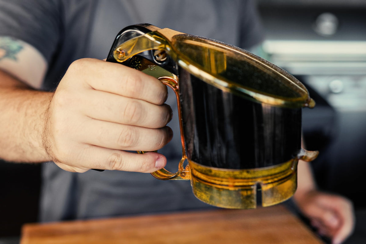 AccuTaste dispenser with clear flip lid showing seasoning levels during cooking.