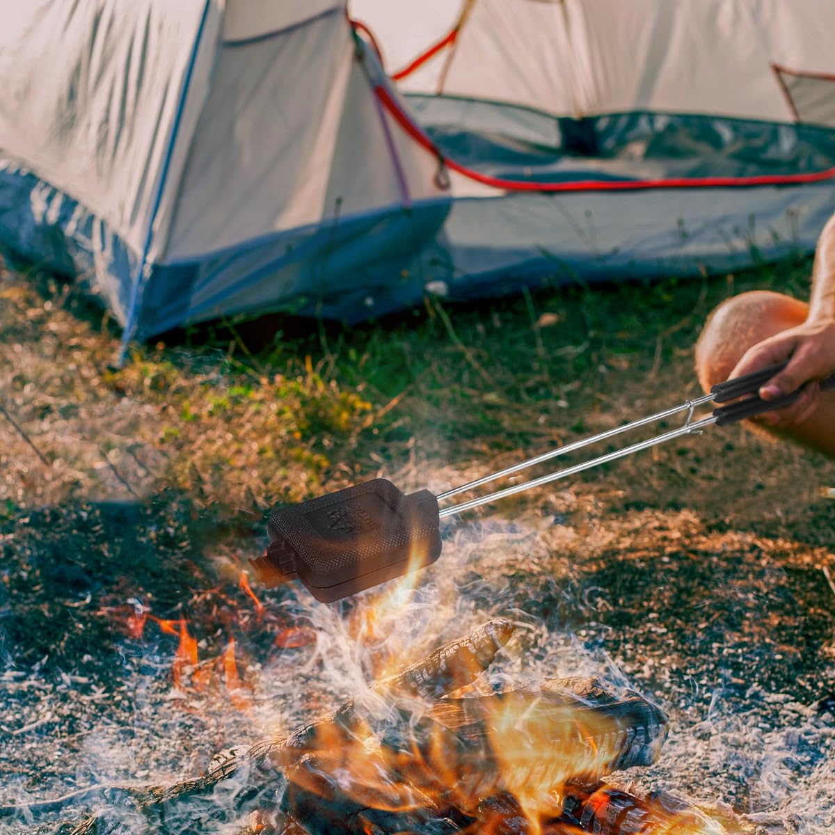 AILITOR camp pie cooker in action grilling sandwiches over a fire.