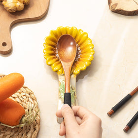 Alarrar sunflower spoon rest with utensils, keeps utensils within reach.