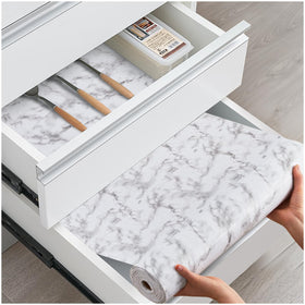 ALIUNI drawer liner in white marble spread to protect shelves from spills.