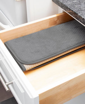 All-Clad pewter mat on countertop complements kitchen decor.