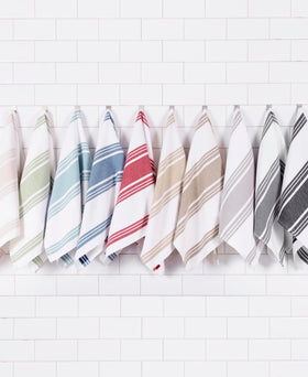 All-Clad towels folded on counter show full size and softness.