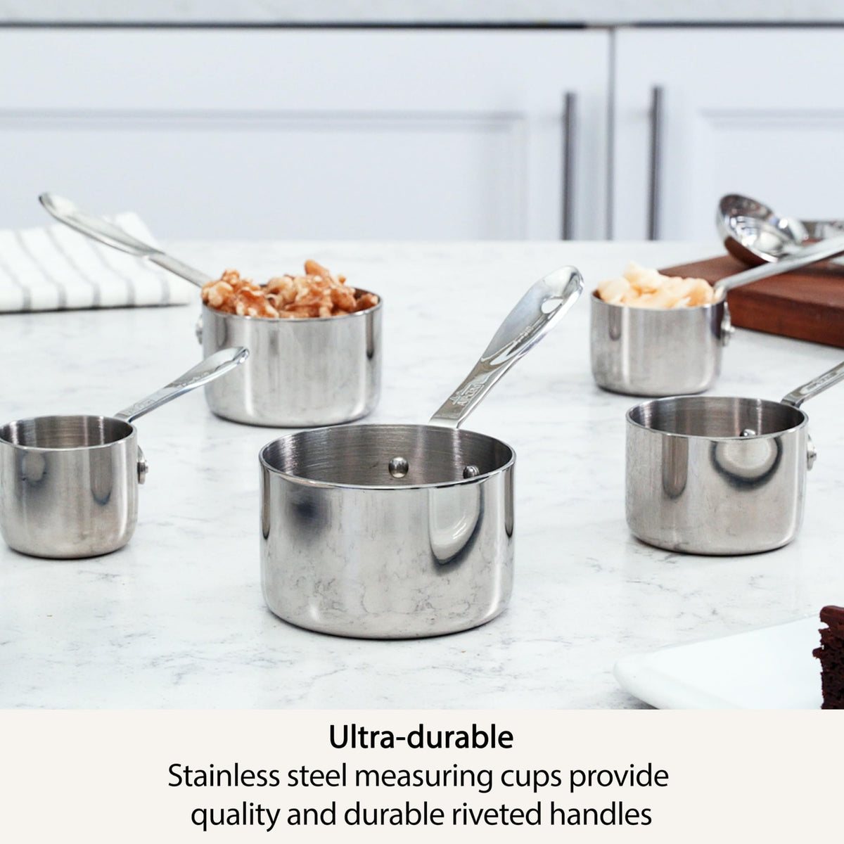 Close-up of All-Clad measuring cups with etched markings for lasting accuracy.