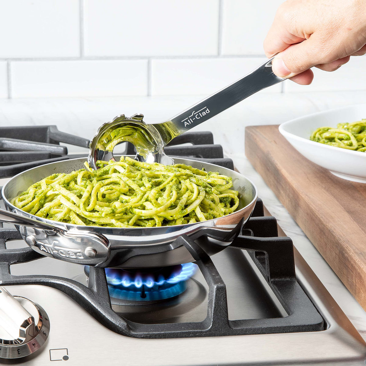 All-Clad stainless steel ladle highlighting large draining holes for clump-free pasta.