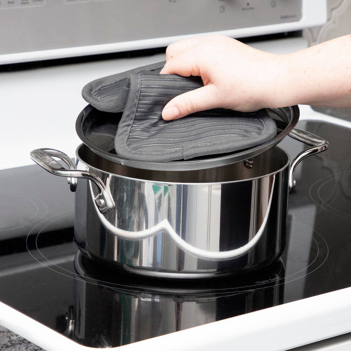 All-Clad pot holder coordinates with kitchen textiles for a cohesive set.