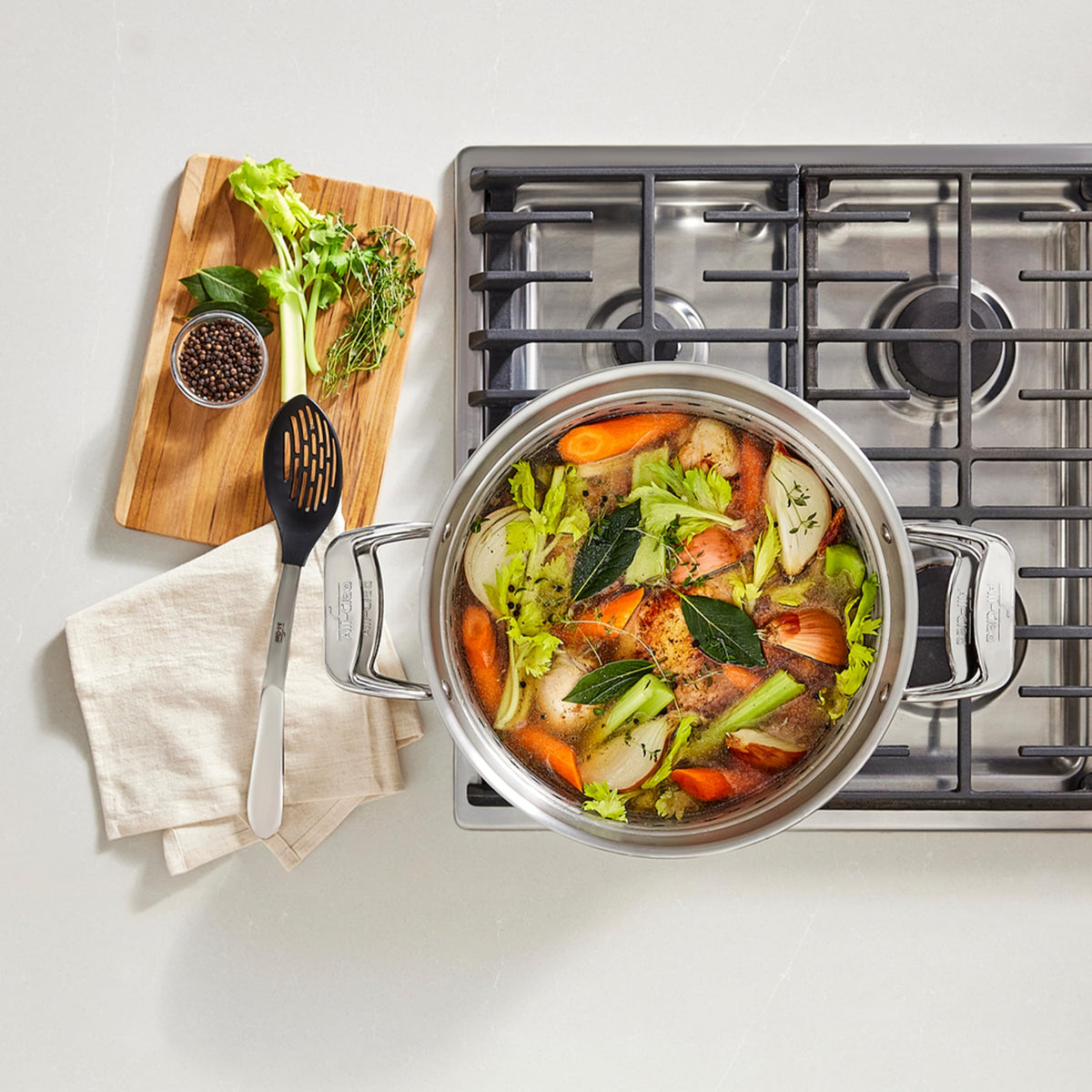 All-Clad Simply Strain 16qt lid shown, oven-safe and induction-compatible for versatile cooking.