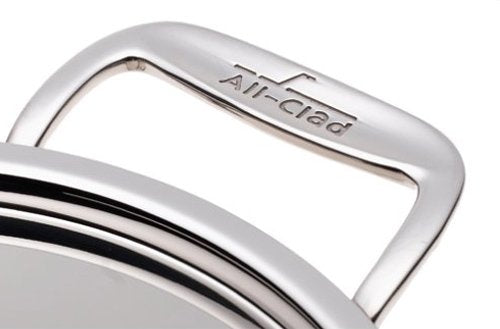 All-Clad steamer insert with handles ready to lift vegetables and seafood