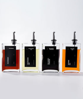 APT 1101 olive oil dispenser set in black with four pourers on a kitchen counter