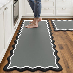 Arenarug scalloped-edge kitchen mats in black and gray provide cushioned comfort for long sink tasks.