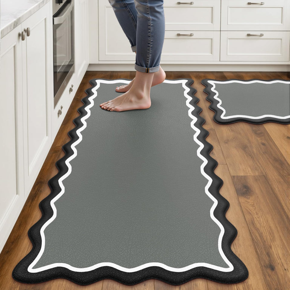 Arenarug scalloped-edge kitchen mats in black and gray provide cushioned comfort for long sink tasks.