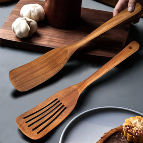 Ayiaren wooden spatula being used to cook in a pan with sauces.