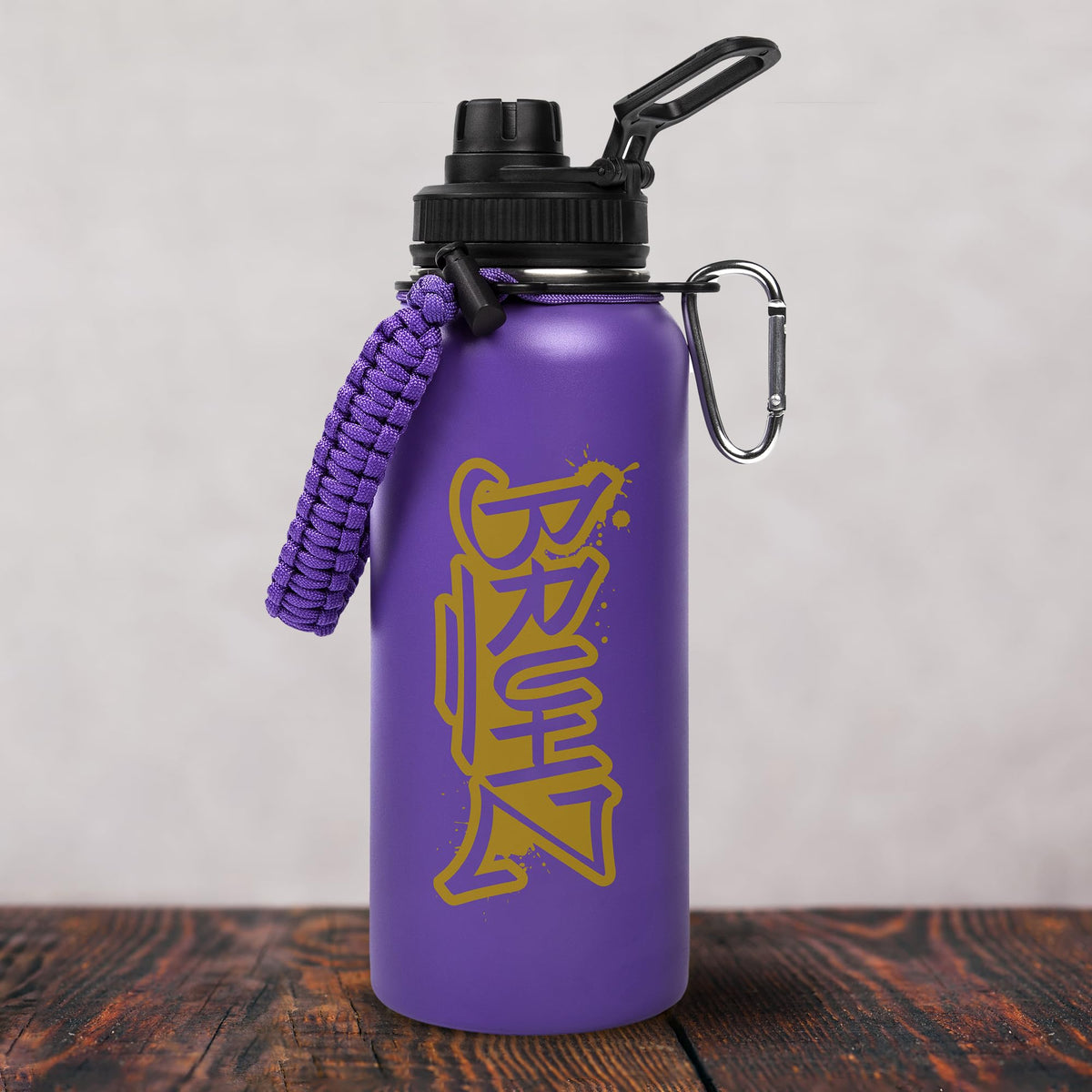 Bad Bananas BBGreek Omega Psi Phi tumbler with paracord handle and carabiner for on-the-go adventures.