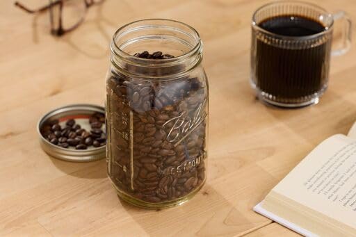Several Ball jars with lids and bands stacked for batch canning.
