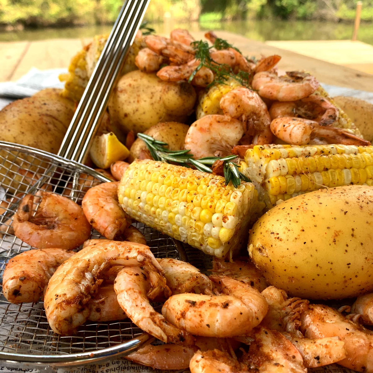 Bayou Classic mesh skimmer in use with a large stockpot for easy lifting.