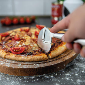 Boska pizza cutter in action slicing pizzas with precision.