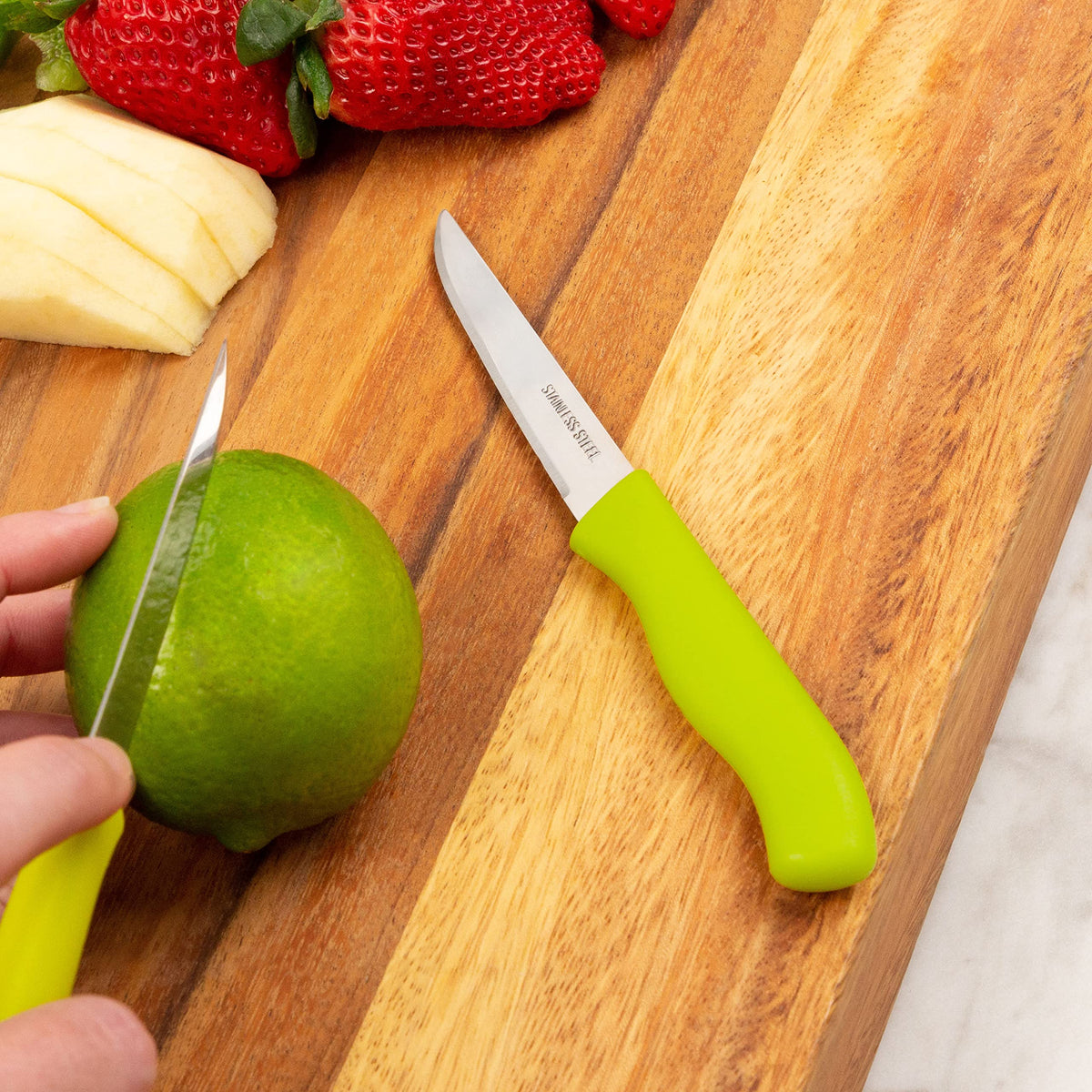 Brenium green paring knife set shown with produce.