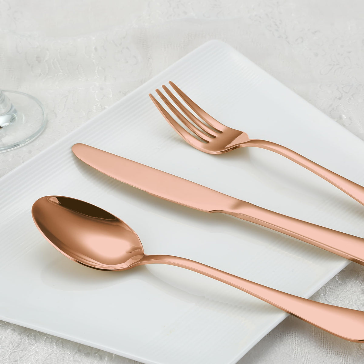 BRIOUT rose gold flatware on dining table demonstrates elegant dinner setup.