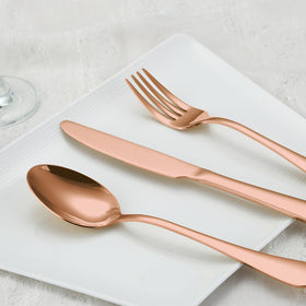 BRIOUT rose gold flatware on dining table demonstrates elegant dinner setup.