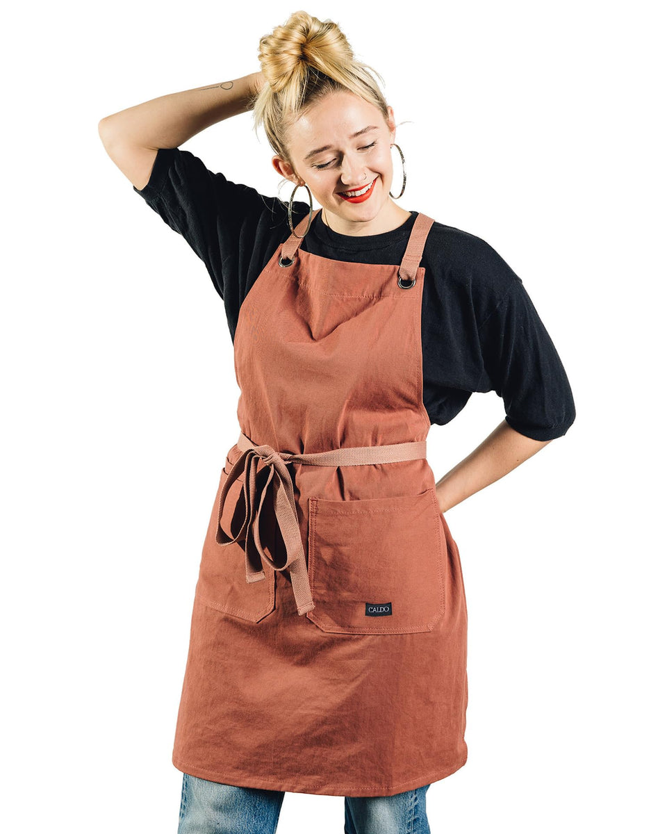 Caldo Crossback apron terracotta front view shows full protection for busy cooks.