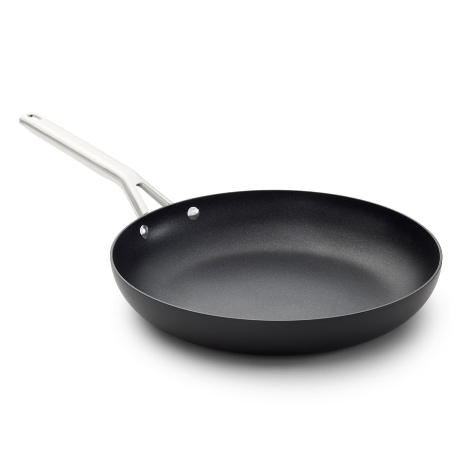 Calphalon hard-anodized 12-inch frying pan on stovetop with even heating for consistent searing.