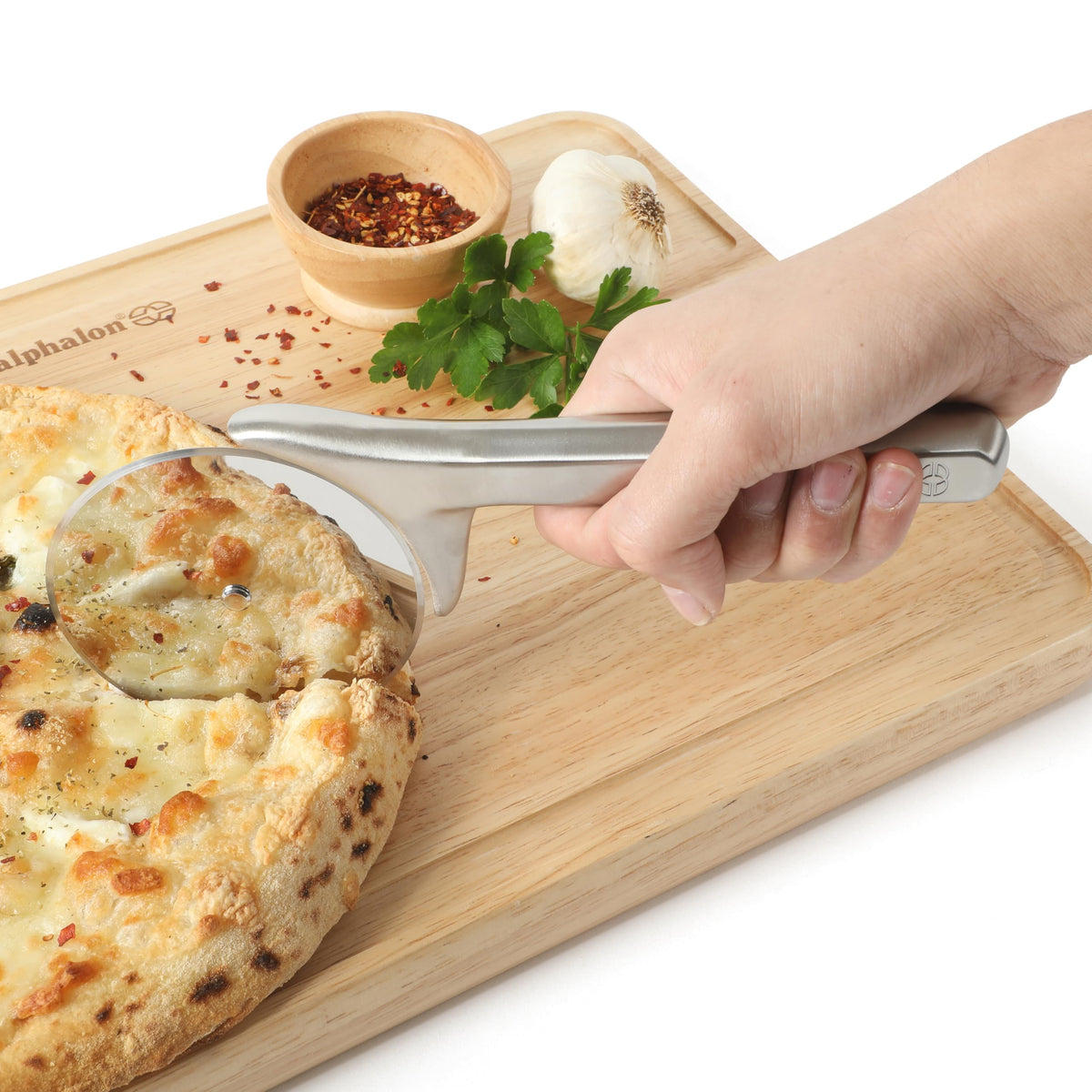 Calphalon Prime pizza cutter in action cutting through crust and toppings.