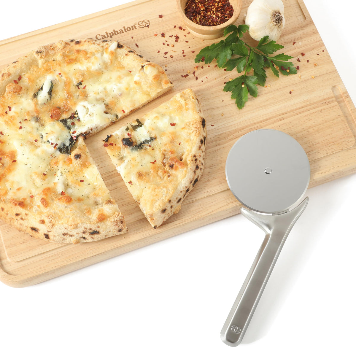 Calphalon Prime pizza cutter with thumb guard for safe, controlled cutting.