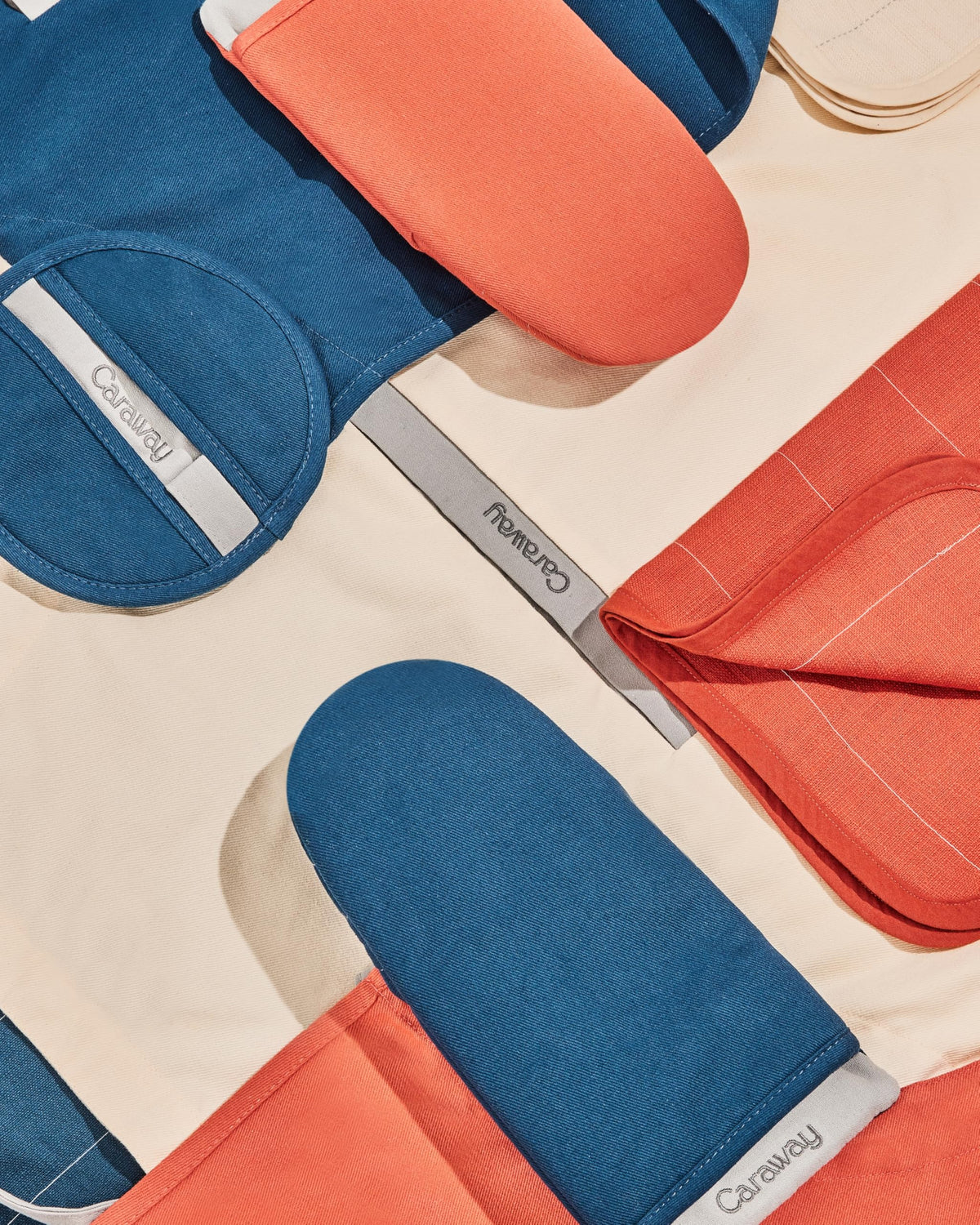 Caraway cream mitts double-layer construction protects hands during high-heat tasks.