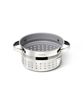 Caraway Steamer Small stainless steel basket inside a pot for vegetables.