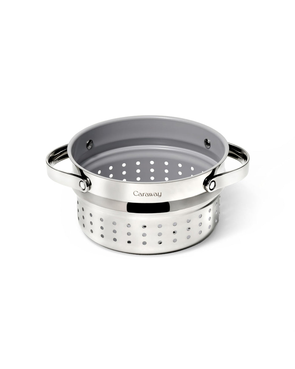 Caraway Steamer Small stainless steel basket inside a pot for vegetables.
