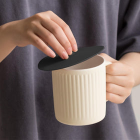 Carrotez two-pack silicone cup lids cover a coffee mug for easy reuse.
