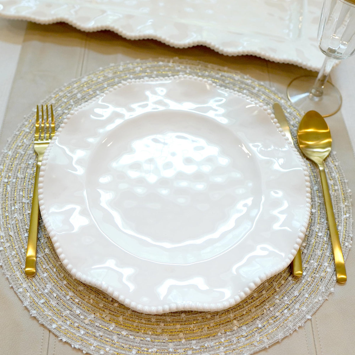 Perlette off-white melamine plates with beaded edge and scalloped design for versatile table settings.