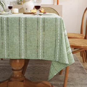 Chassic sage-green tablecloth enhancing a cozy kitchen dining area.