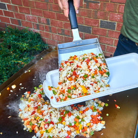Cuisinart Griddle Food Mover in use during cooking on a busy griddle.