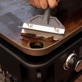 Cuisinart heavy-duty griddle scraper ideal for outdoor grilling cleanup after a barbecue.