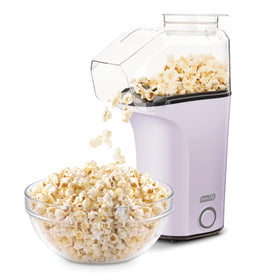 DASH hot air popcorn popper with measuring cup for precise portions.