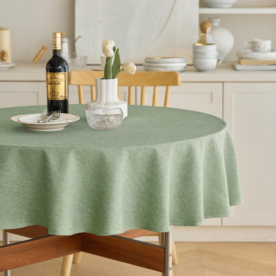 Decorelia faux linen round tablecloth sage green with waterproof protection for spills.