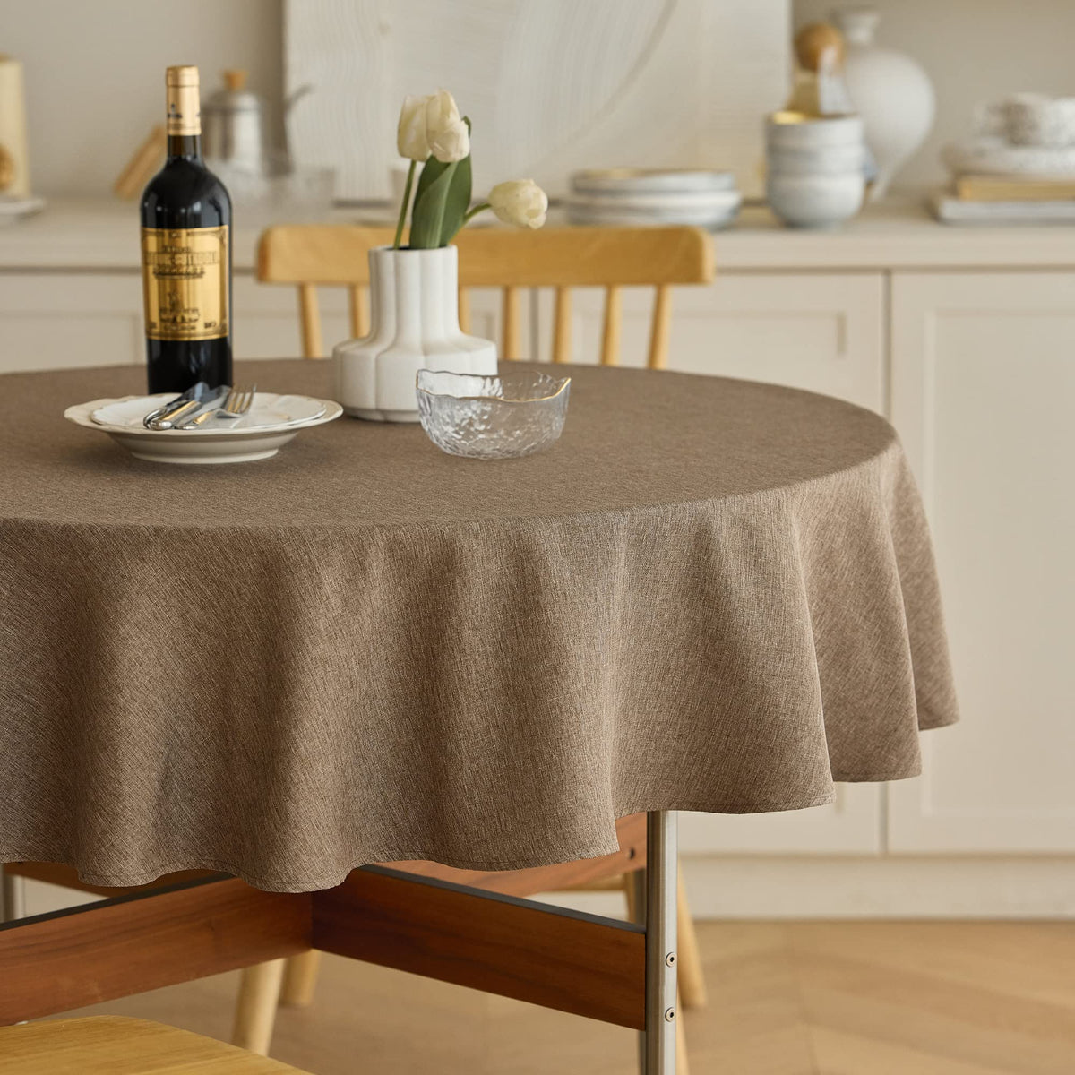 Decorelia waterproof round tablecloth in coffee covers two to four seat tables and protects surfaces.