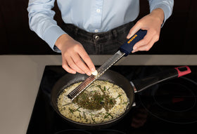 Deiss PRO black grater, curved sides enhance rigidity for tough grating tasks.