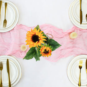 Dekafri pink cheesecloth table runner during baby shower setup with pastel decor.
