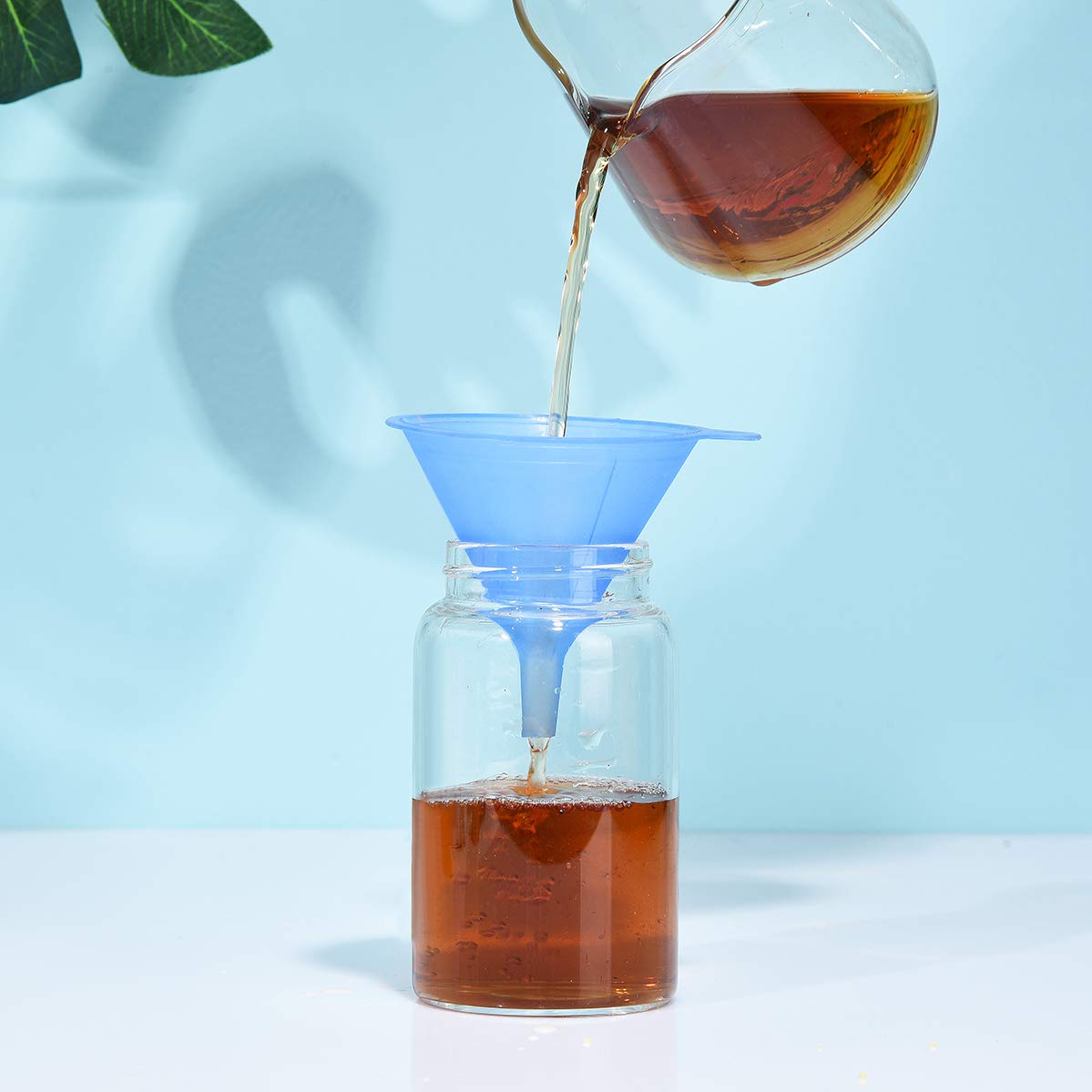Delove funnels in action for pouring into bottles without drips.