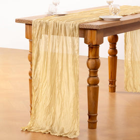 8-10 seat table setting featuring DeZerlor champagne gold cheesecloth runner.