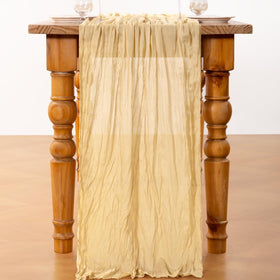Dining table styled with DeZerlor champagne gold cheesecloth runner for bridal ambiance.