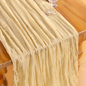 Outdoor wedding dining with DeZerlor champagne gold cheesecloth runners.
