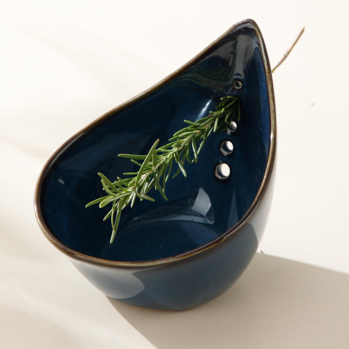 Dneuoir herb stripper bowl close-up highlights five holes for thyme, basil, and more.