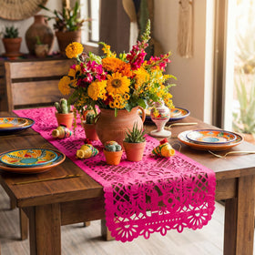 Eaasty green papel picado table runner enhances vibrant decor.
