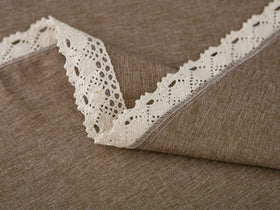 Stain-resistant tablecloth in a dining setting with lace trim detail.