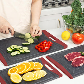 Empune red cutting boards on a kitchen counter ready to use.