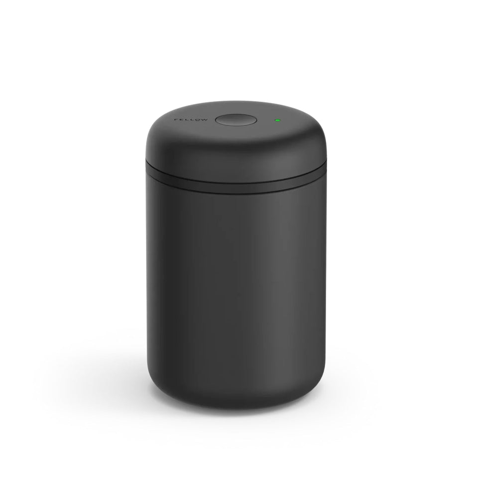 Fellow Atmos canister with airtight seal on the counter keeps whole beans fresh.