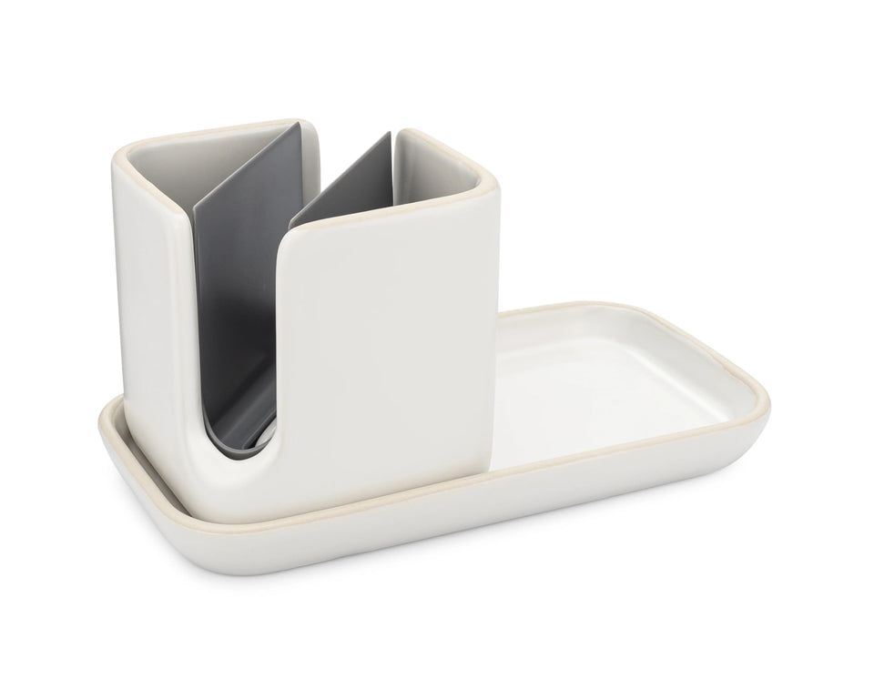 Full Circle Stash ceramic sink caddy keeps cleaning tools organized beside the sink.